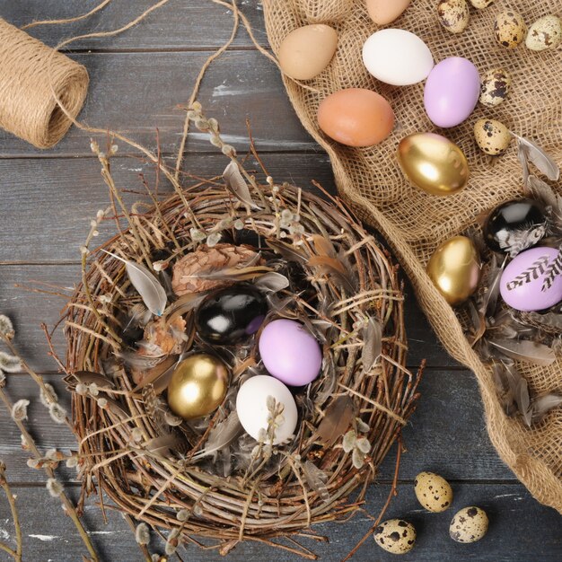 Photo oeufs et plumes colorés de différentes tailles pour pâques. boho stile.