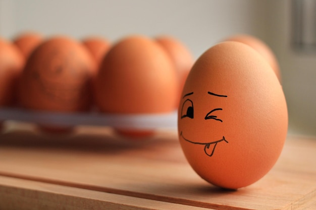 Oeufs de poule beige avec visage riant sur stand d'oeufs