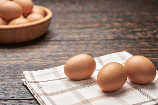 Oeufs de poule bio dans un bol en bois sur une table de cuisine