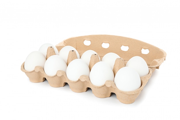 Oeufs de poule blancs dans une boîte en carton isolé sur blanc