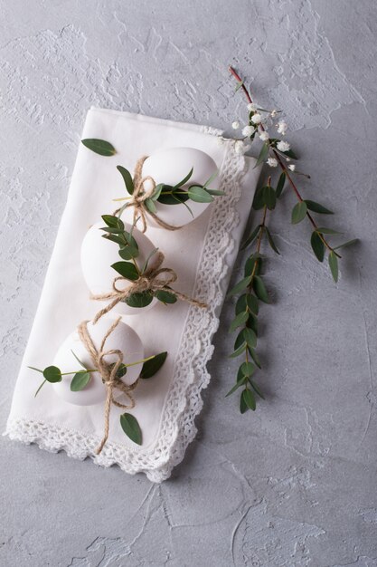 Oeufs de poule blancs avec décor de Pâques sur une serviette blanche. Tendance déco maison