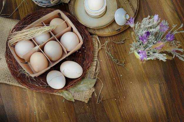 Oeufs de poule crus biologiques dans une boîte à oeufs de paille sur fond de bois de style ancien