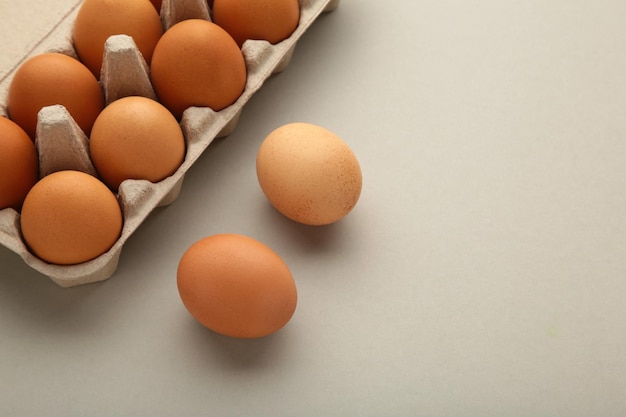 Oeufs de poule dans une boîte à oeufs ouverte sur gris Vue de dessus avec espace de copie Concept d'aliments sains naturels et d'agriculture biologique