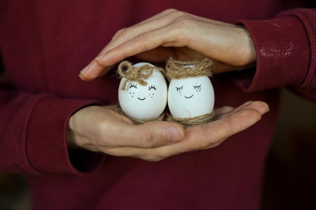 Oeufs de poule dans les mains des hommes Oeufs peints à la main Oeufs de Pâques Le thème de cette année est simple