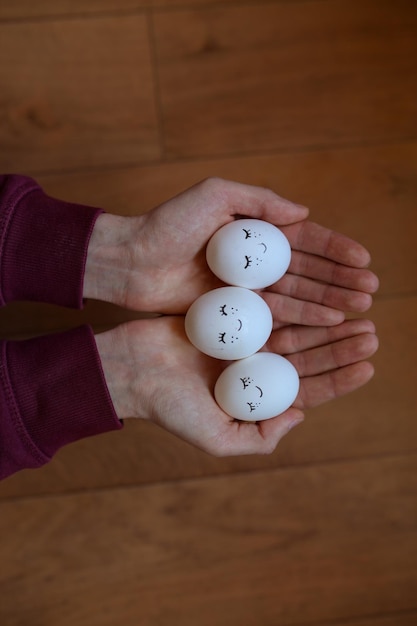 Oeufs de poule dans les mains des hommes Oeufs peints à la main Oeufs de Pâques Le thème de cette année est simple