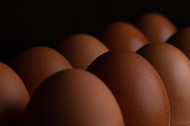 Des œufs de poule dans un panier en osier et sur une serviette
