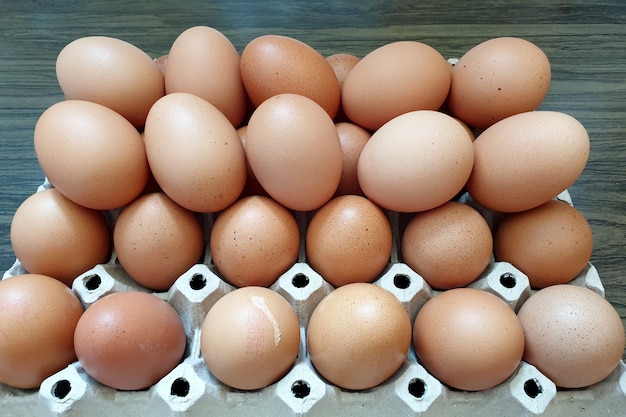 Oeufs de poule frais dans l'emballage sur un fond en bois