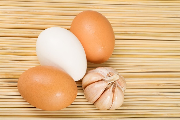 Oeufs de poulet et d'ail sur la table en bois