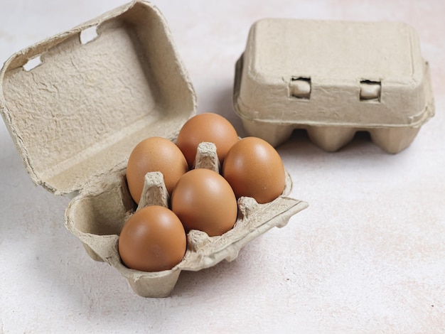 Oeufs de poulet dans une boîte en carton sur fond blanc