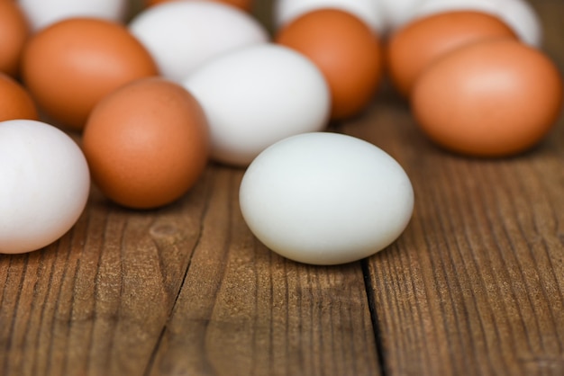 Oeufs de poulet frais et oeufs de canard sur table en bois / oeuf blanc et brun