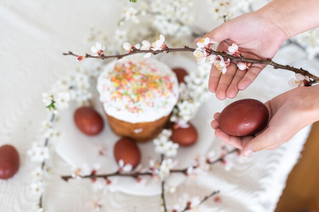 Oeufs rouges pour Pâques, menu traditionnel de Pâques, mains tenant des oeufs peints.