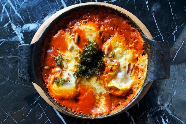 Oeufs shakshuka dans une poêle à frire sur une table, vue de dessus