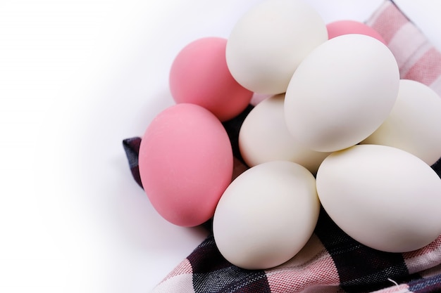 Les oeufs sont couchés sur le tissu, avec un fond blanc.