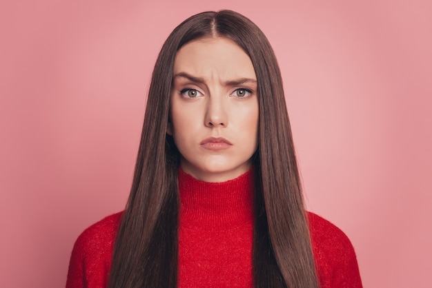 Offensé jeune femme portant un t-shirt décontracté fronçant les sourcils isolé sur fond rose