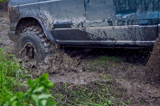 Offroader calé dans la boue lors d'une course hors route les roues glissent sur la gadoue