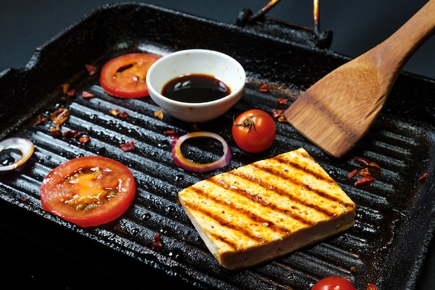 Ofu sur le grill sur la table sur fond noir, vue du dessus.