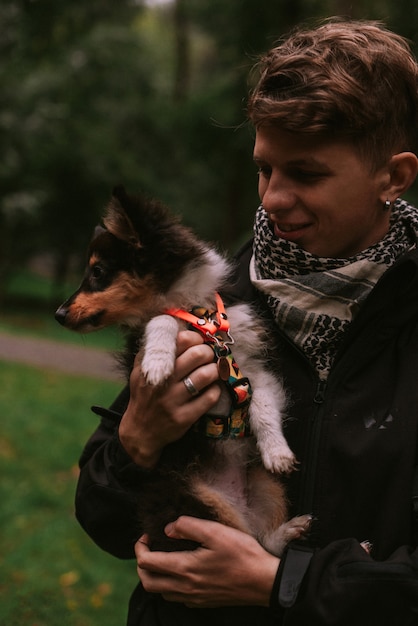 Og propriétaire tenant un chiot sur les mains