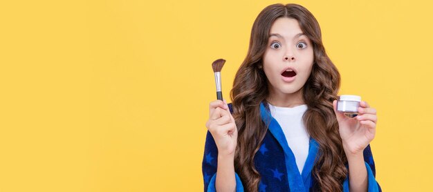 Oh pas d'adolescente choquée tenir un pinceau à poudre enfant dans des vêtements de nuit utiliser des cosmétiques Cosmétiques pour adolescent