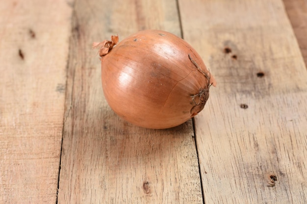 oignon entier frais sur fond de bois