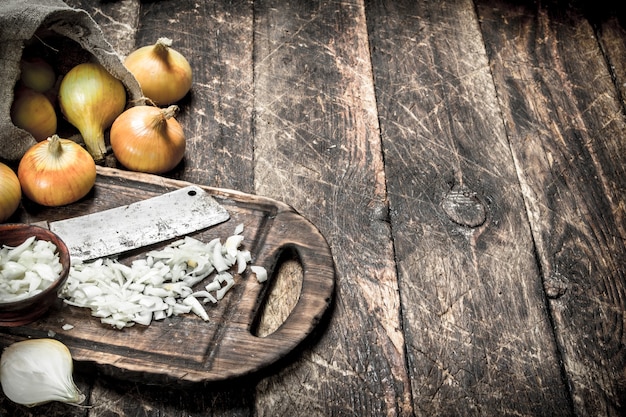 Oignon frais avec vieille hache sur une planche à découper sur un fond en bois