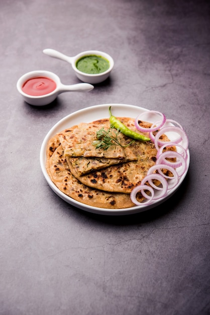 Oignon Parotha ou Pyaj parantha ou kanda paratha servi avec du ketchup et du chutney vert.