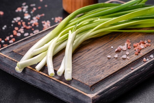 Oignon vert ou échalote sur planche de bois ciboulette printanière fraîche