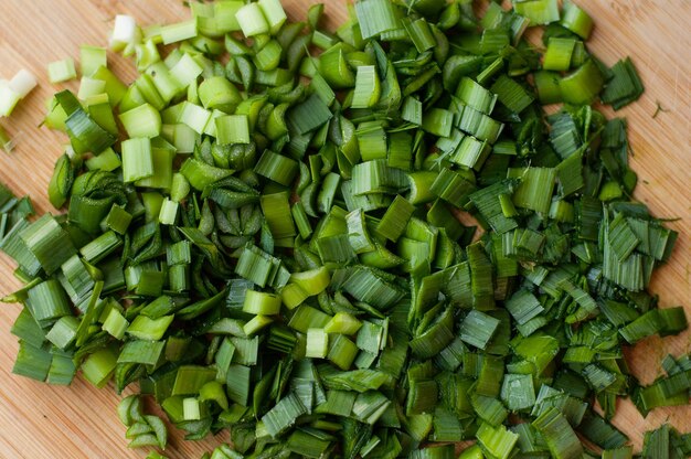 Oignon vert finement haché sur une planche de bois