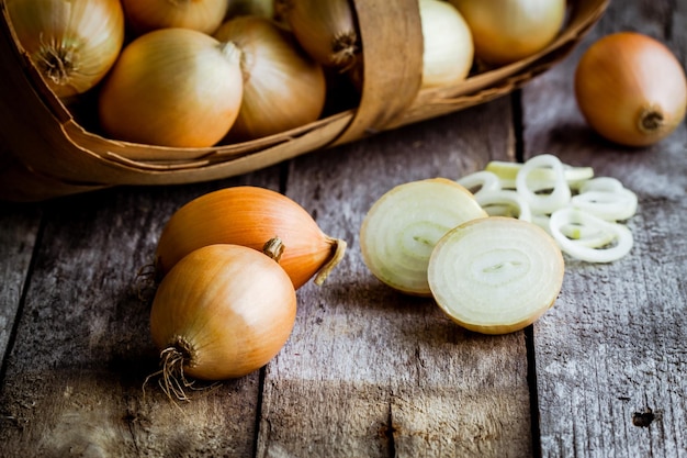 Oignons biologiques frais dans un panier sur un fond en bois