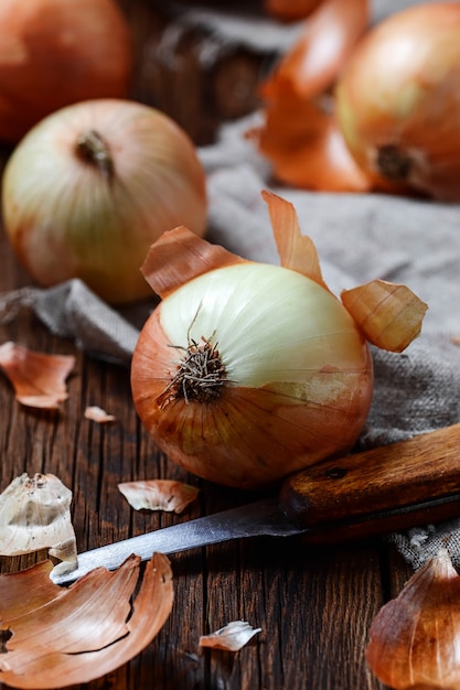 Oignons crus sur fond en bois