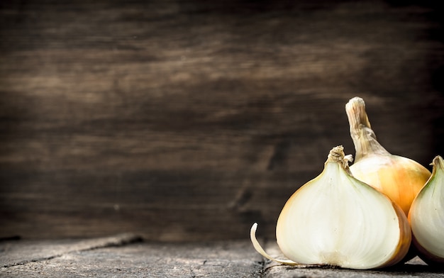 Oignons frais et mûrs. Sur un fond en bois.