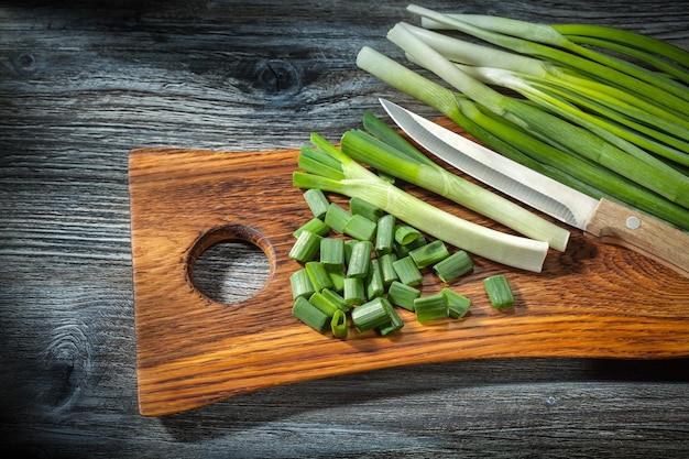 Oignons hachés et couteau de cuisine sur planche à découper en bois fond bois vintage