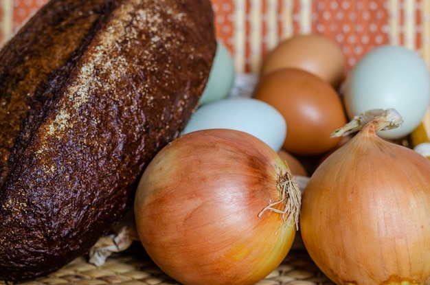 Oignons et œufs sur un panier avec du pain et des œufs