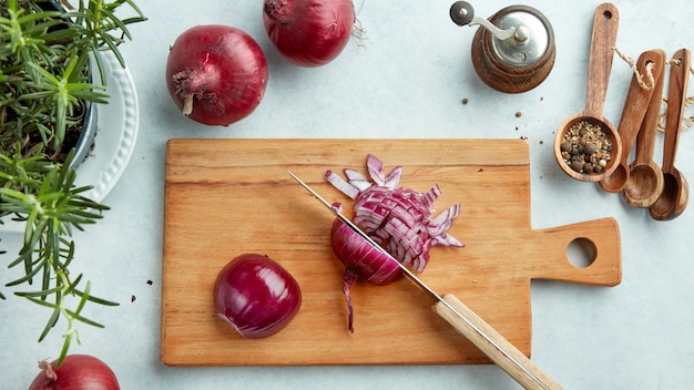 Oignons rouges hachés sur planche à découper en bois, vue de dessus