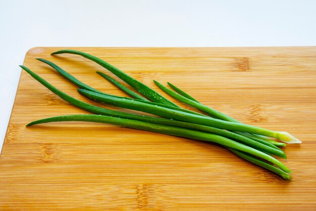 Oignons verts frais sur une planche à découper. Gouttes d'eau sur un oignon vert fraîchement coupé. Nutrition adéquat