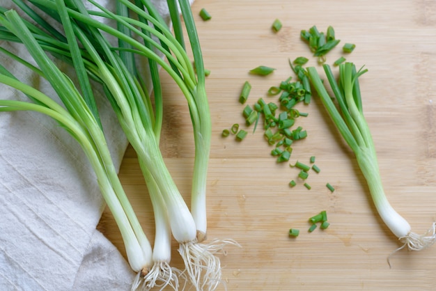 oignons verts tranchés sur table en bois