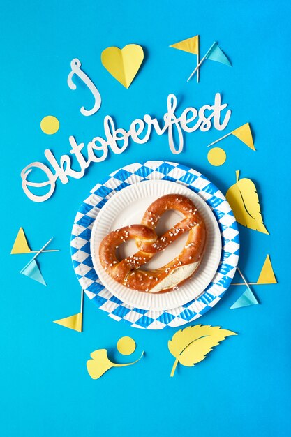 Oktoberfest, bretzel sur assiette jetable bleu et blanc, drapeaux décoratifs et décorations d'automne