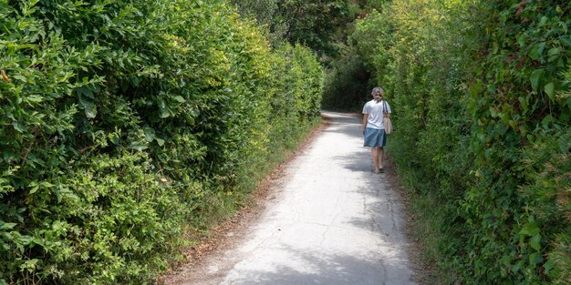 Old senior woman walk in path dans l'île d'Aix Charente maritime en France