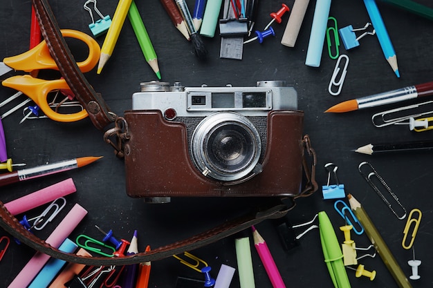 Old Vintage Camera entre école stationnaire sur tableau noir