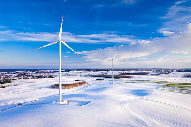 Éolienne sur champ neigeux en hiver au lever du soleil