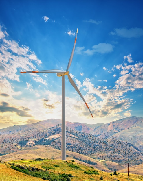 Éolienne sur une colline contre le ciel coucher de soleil