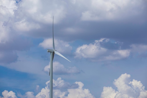 Éolienne sur l'herbe brune au-dessus de la montagne bleue