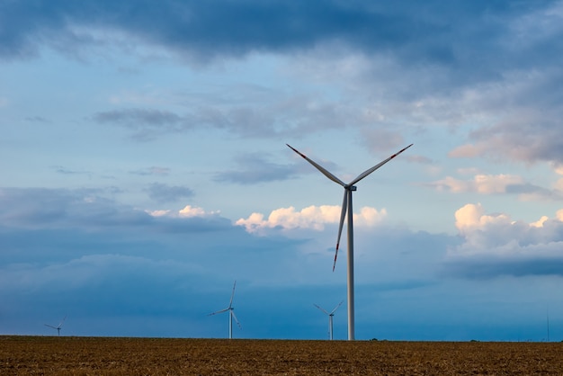 Éolienne sur le terrain. Paysage avec moulins à vent contre ciel nuageux. Énergie écologique verte