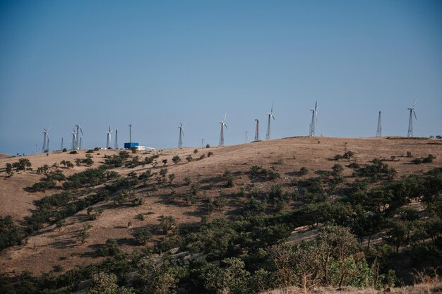 Éoliennes dans un parc éolien dans les montagnes pour produire de l'énergie écologique sous un ciel bleu