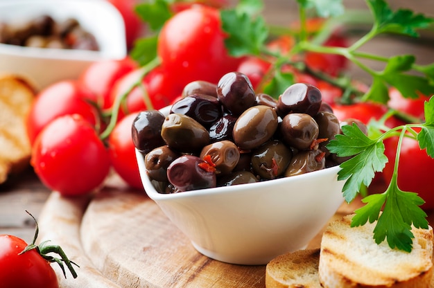 Olive avec tamato et persil sur la table en bois