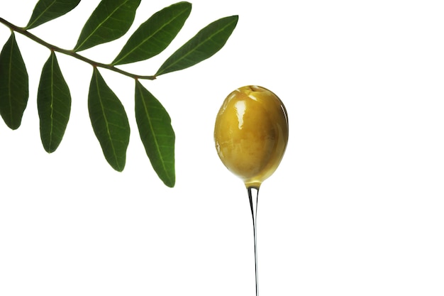 Olive verte avec de l'huile isolé sur une surface blanche