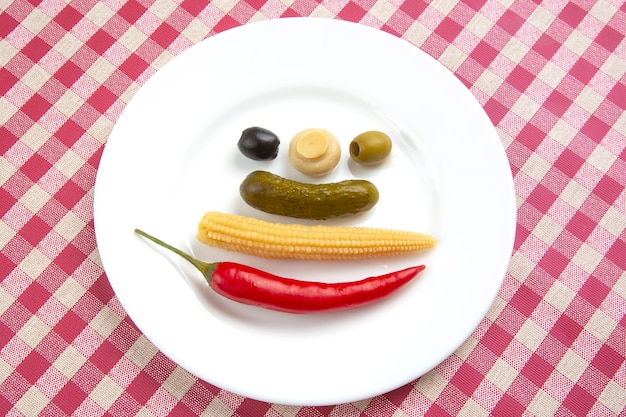 Olives, concombre mariné, poivron, champignons et maïs dans une salade sur une assiette