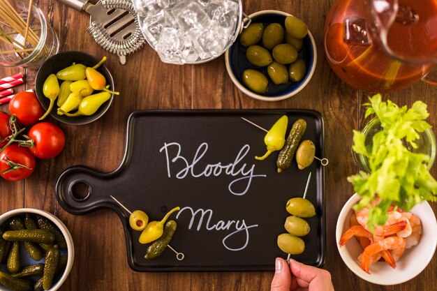 Olives, cornichons, céleri et crevettes cocktail pour garnir le cocktail Bloody Mary.