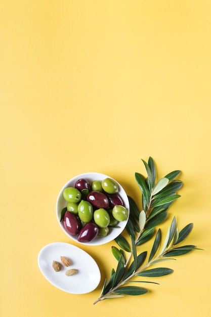 Olives fraîches et branche d'olivier sur une table