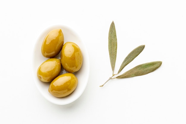 Olives jaunes sur assiette avec des feuilles