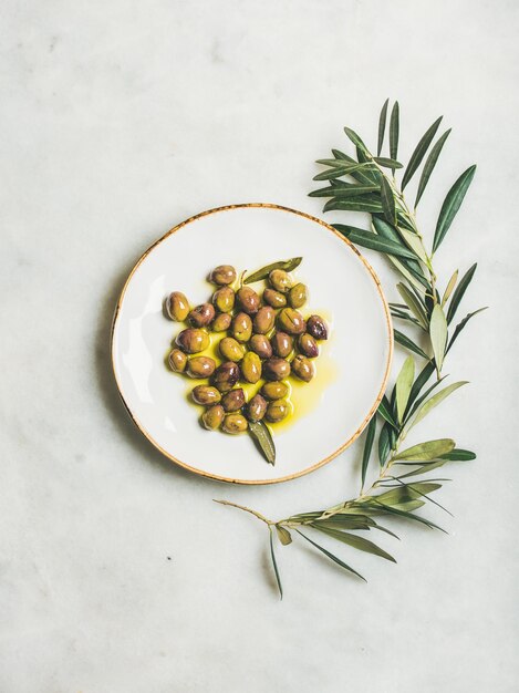 Olives méditerranéennes vertes marinées à l'huile d'olive vierge sur assiette